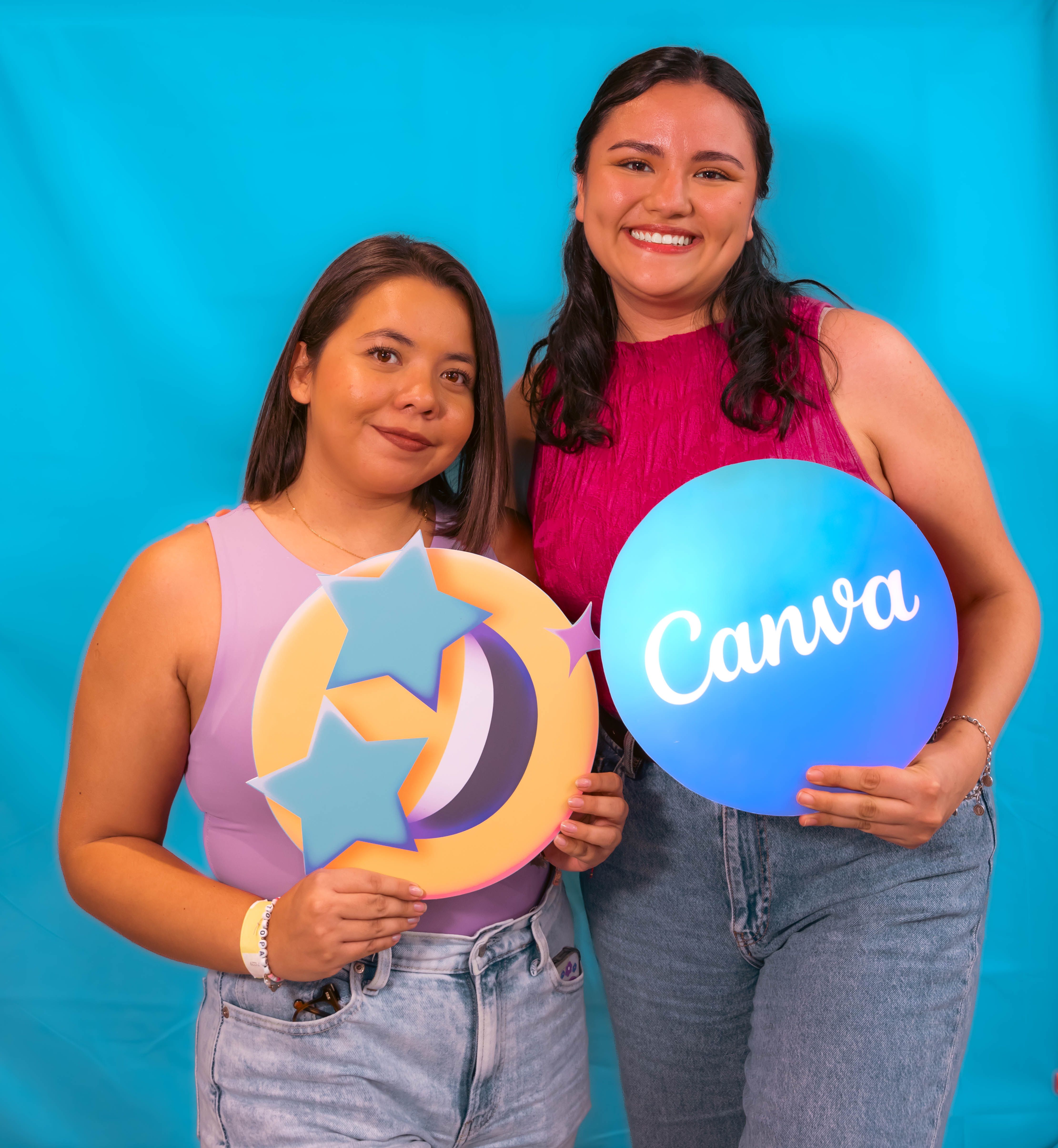 Two smiling women holding Canva and star symbols on a blue background.