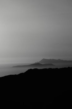 Minimalist seascape with Greek islands silhouetted at dusk, showcasing serene beauty.