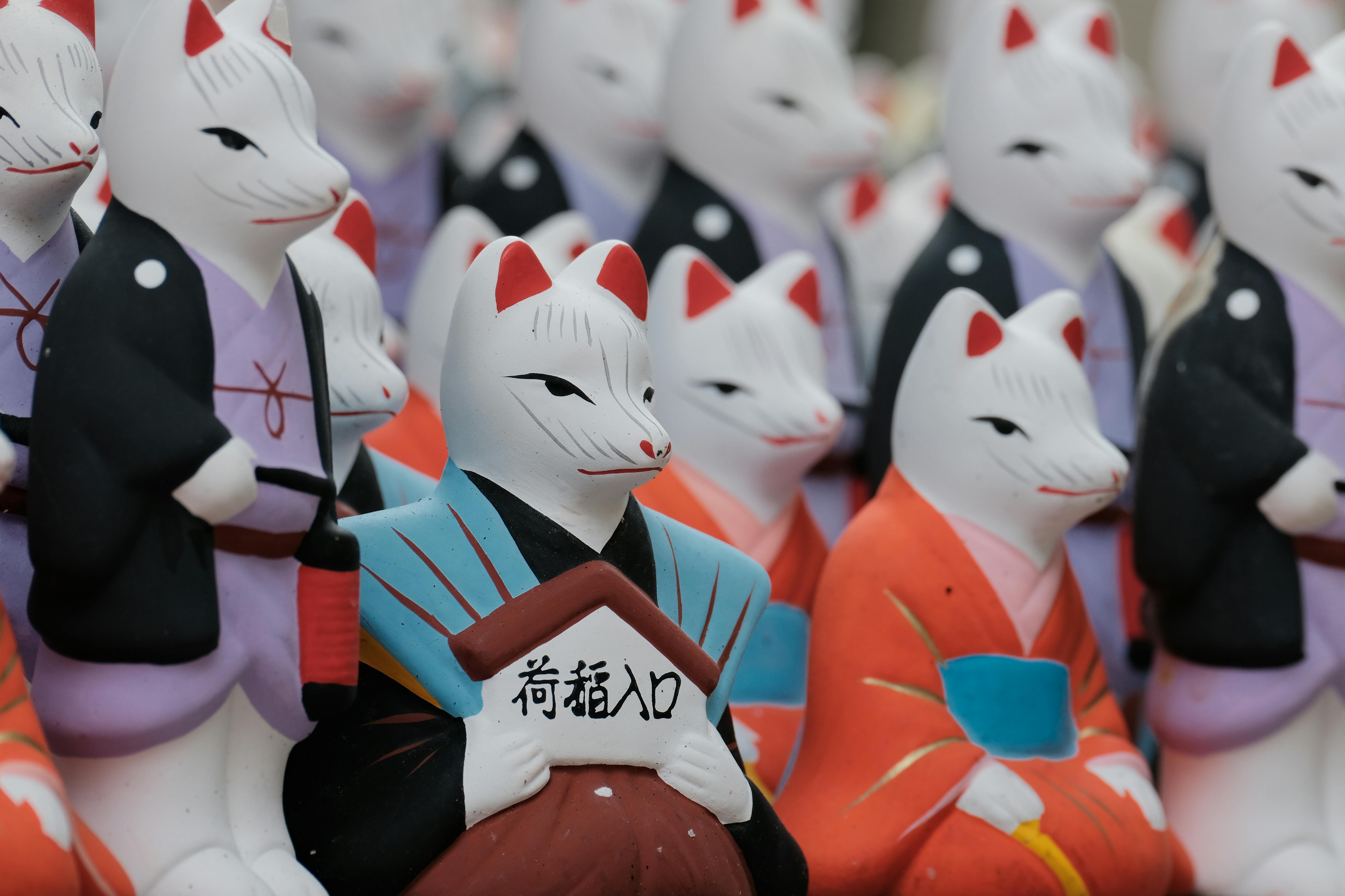 colorful kitsune statues at a japanese shrine