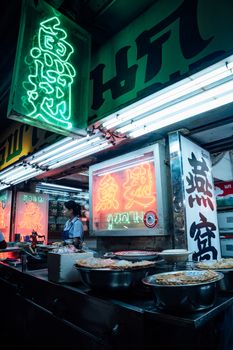 Explore the lively atmosphere of a Bangkok night market with neon-lit food stalls.