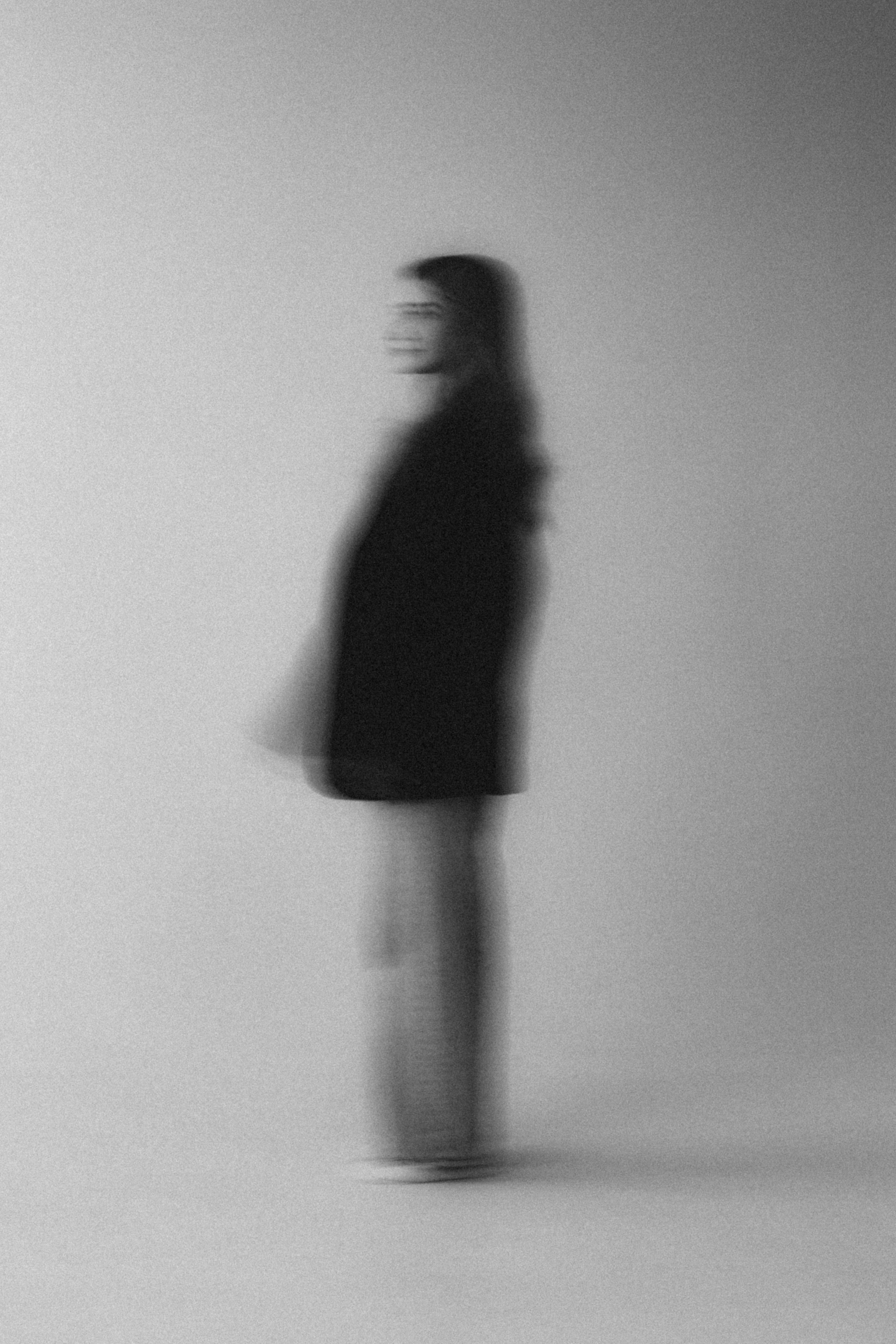 Foto artistica in bianco e nero di una donna in sfocatura di movimento.