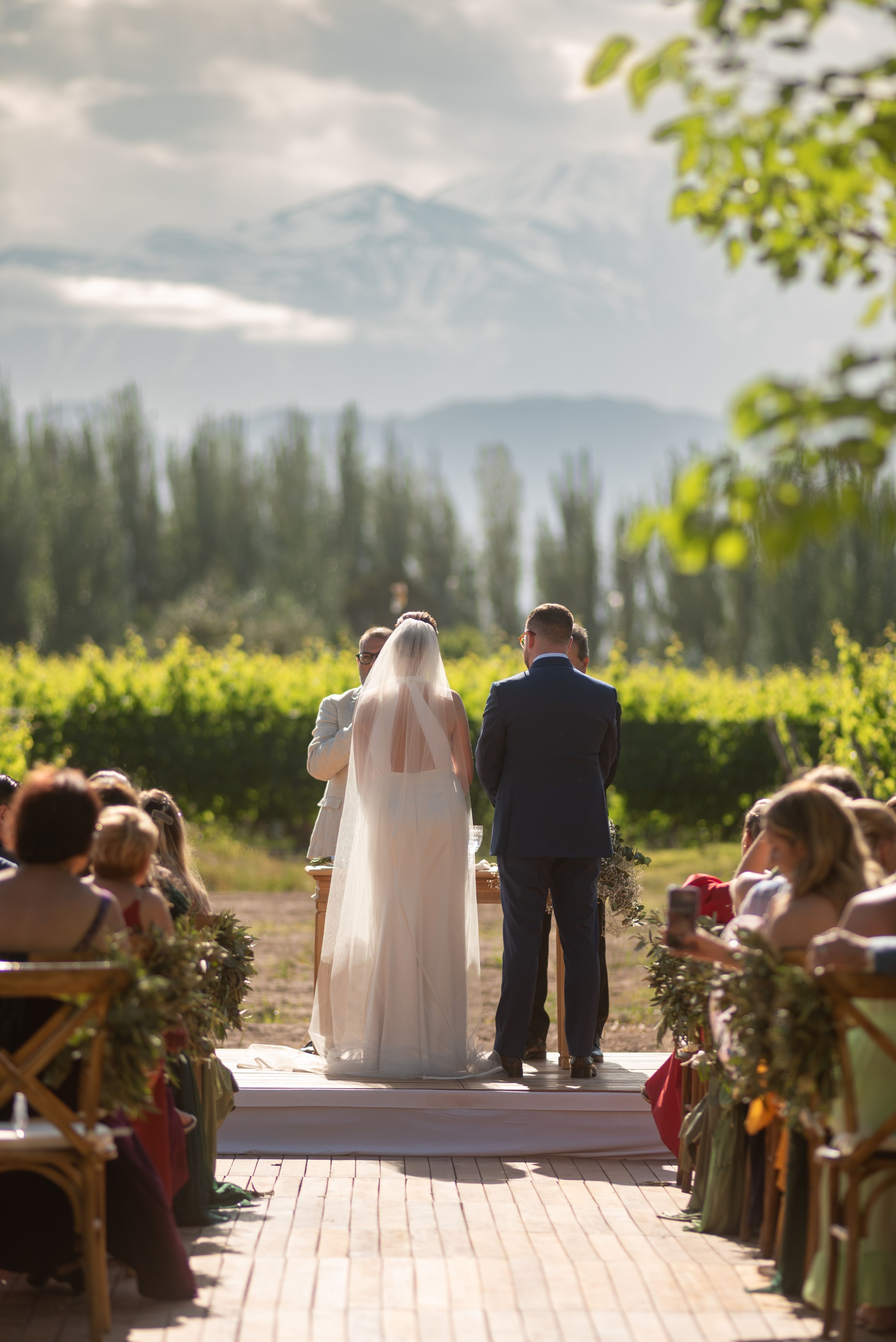 A stunning outdoor wedding ceremony set in a beautiful Mendoza vineyard with mountain backdrop.