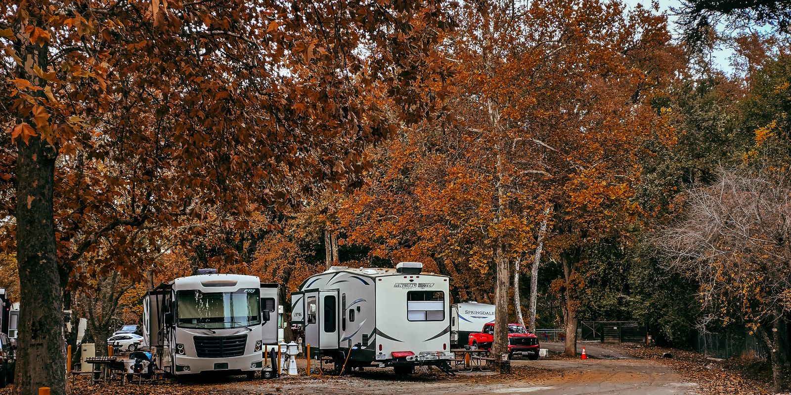 A cozy RV campsite surrounded by vibrant fall foliage in a serene forest