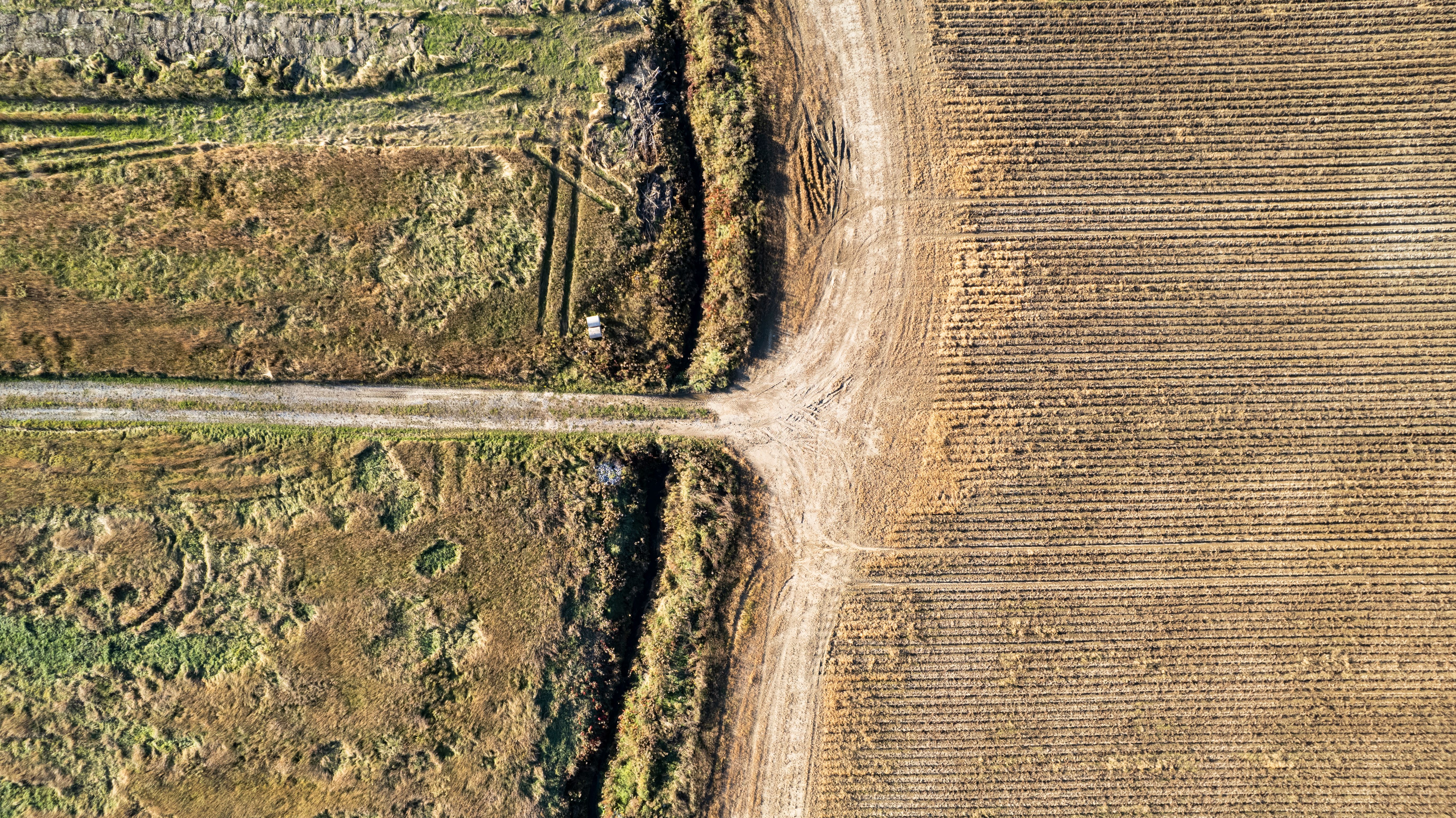 Drone shot of intersecting farmland and dirt road in rural Québec, Canada.