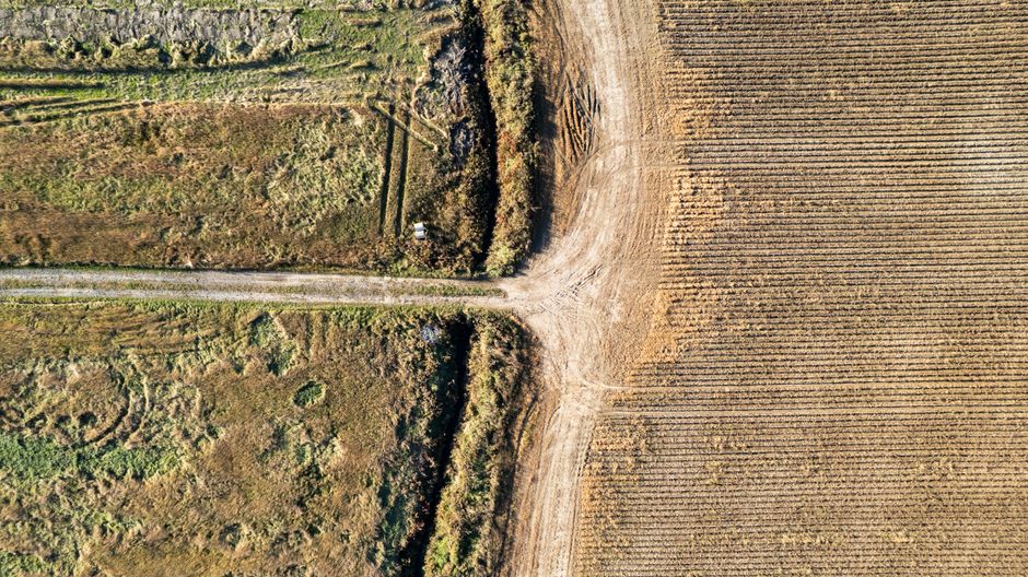Drone shot of intersecting farmland and dirt road in rural Québec, Canada.
