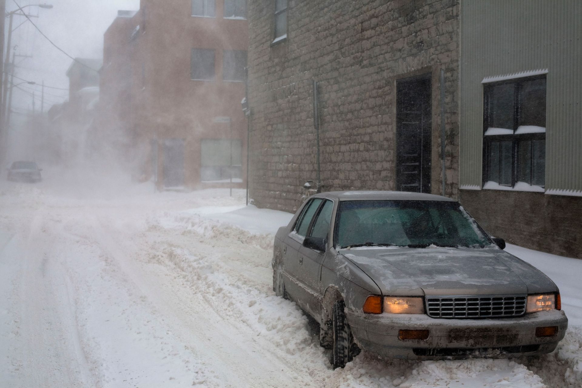 A snowstorm in Quebec city, Canada. View from the street with a lot of snow behind a stuck car in the snow.