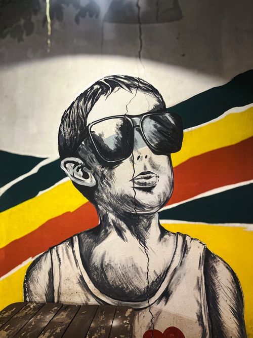Free Vibrant street art mural depicting a boy with large sunglasses. Stock Photo