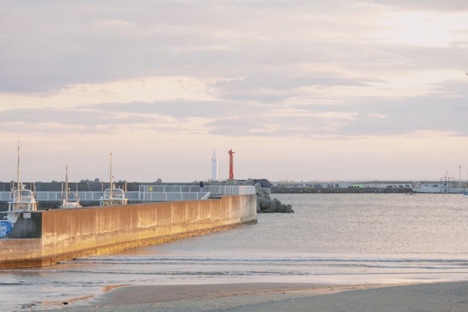 Tranquil seaside view with a pier and lighthouse, perfect for travel and leisure themes.