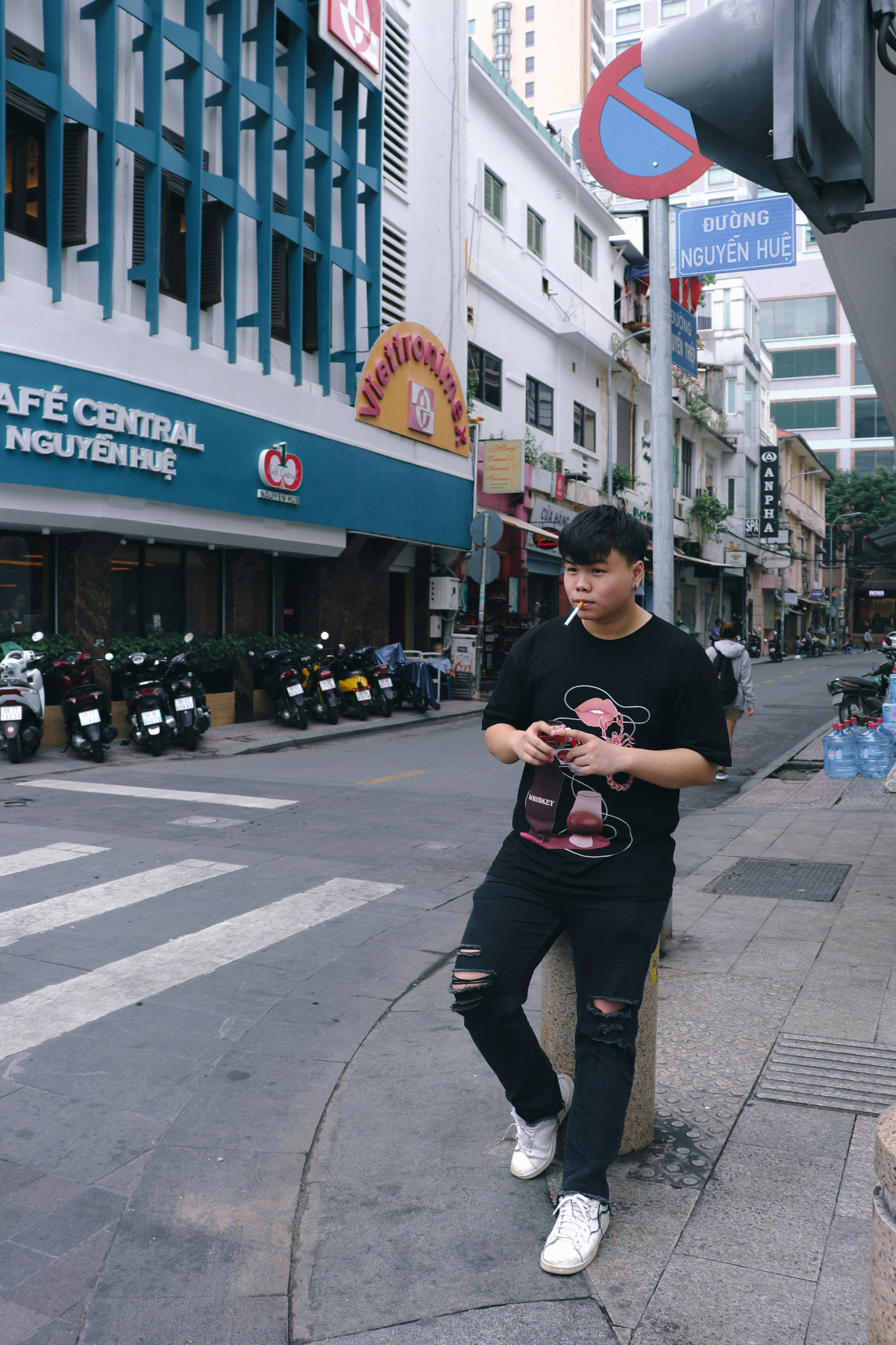A young man stands by the roadside on Nguyễn Huệ street in Hồ Chí Minh City, Việt Nam.