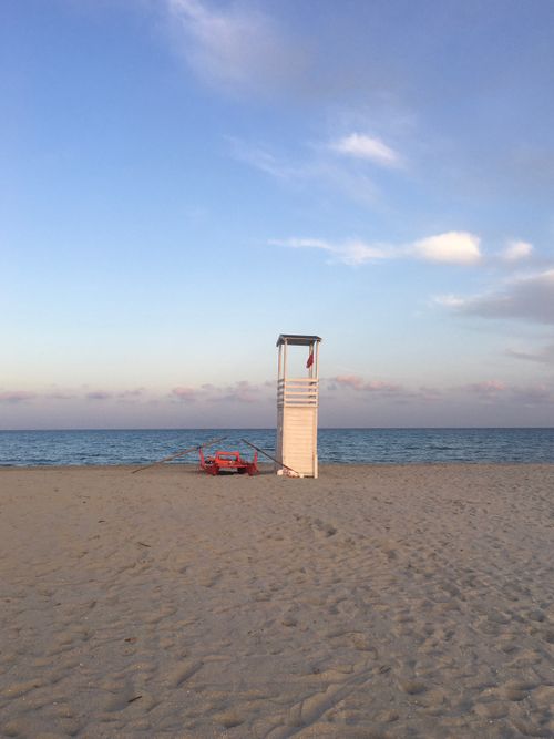 Free A peaceful Sardinian beach with a solitary lifeguard tower at sunset, showcasing Mediterranean beauty. Stock Photo