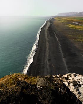 从悬崖上可以欣赏到冰岛黑沙滩的壮丽景色和火山景观