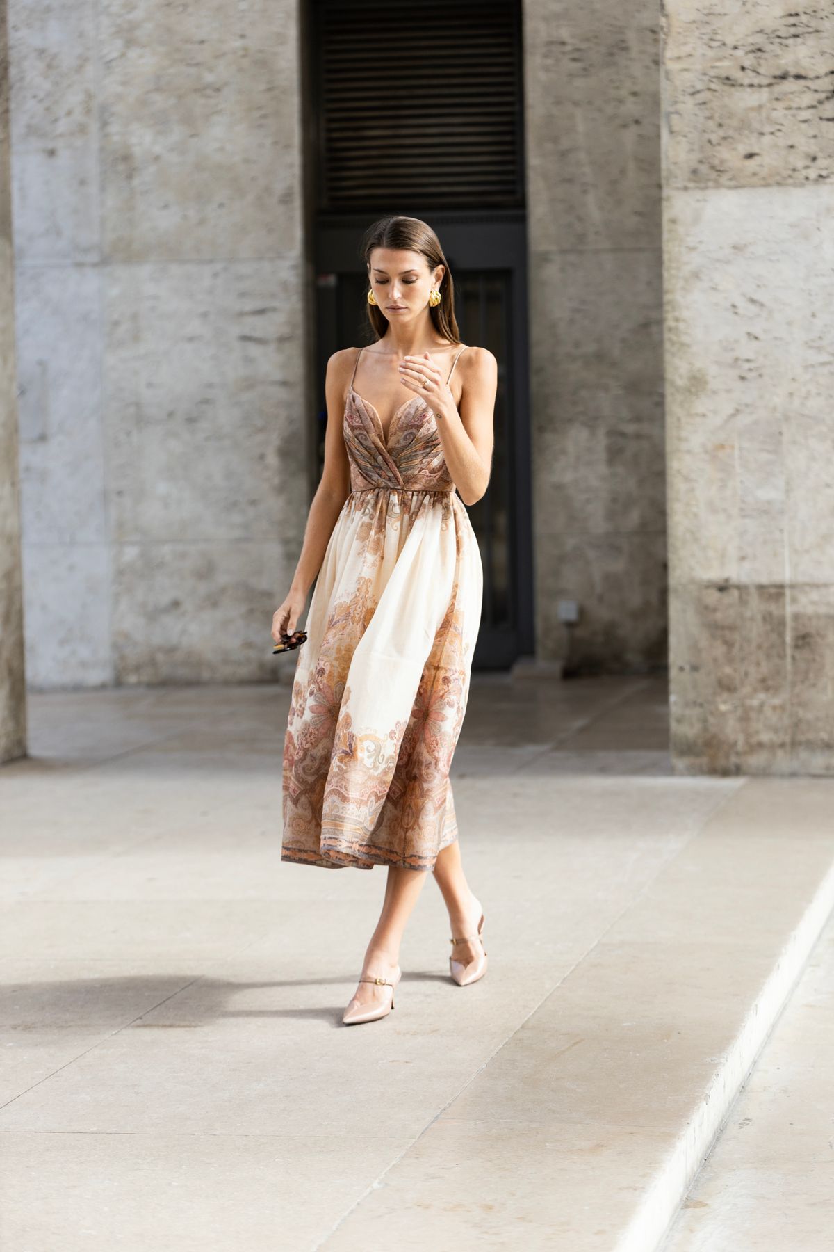 An elegant woman walking in a Paris street in a voluminous dress — styling the ruffle with restraint