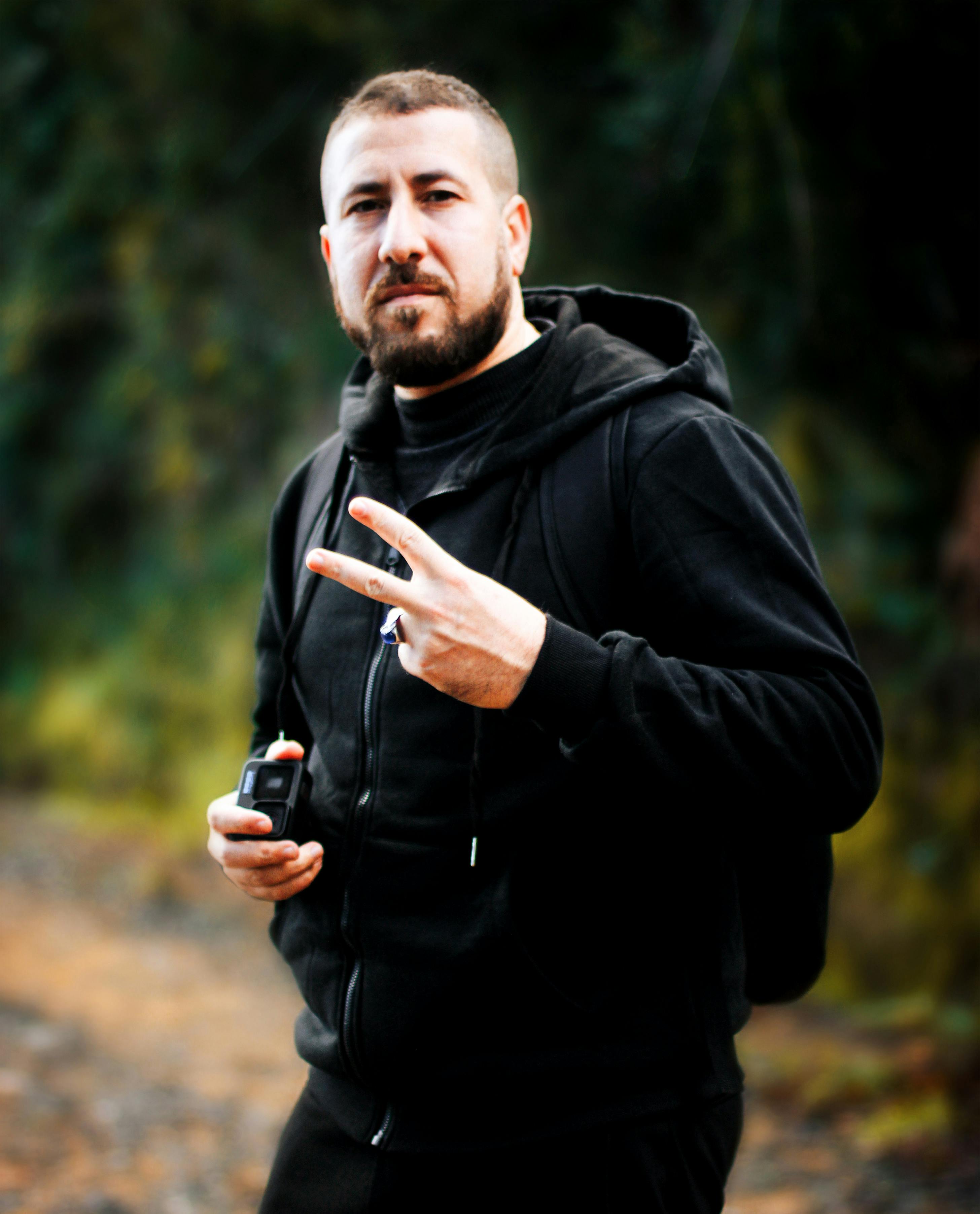 Casual portrait of a man in Kanoua, Skikda Province, Algeria, showing a peace sign.
