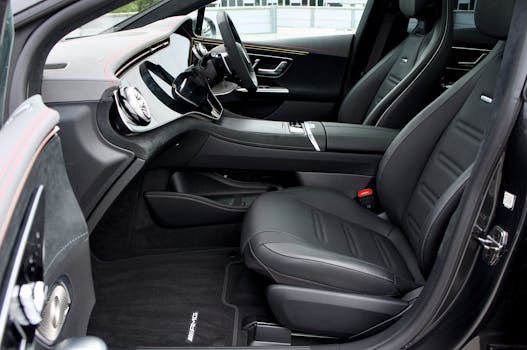 Sleek interior of a luxury car featuring black leather seats and a high-tech dashboard design.