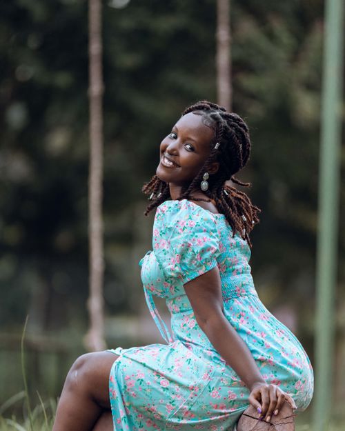 Free Happy woman in a floral dress smiling outdoors, showcasing natural beauty. Stock Photo