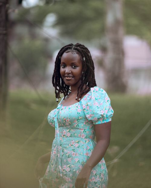 Free Charming outdoor portrait of a woman in a floral dress with natural background. Stock Photo