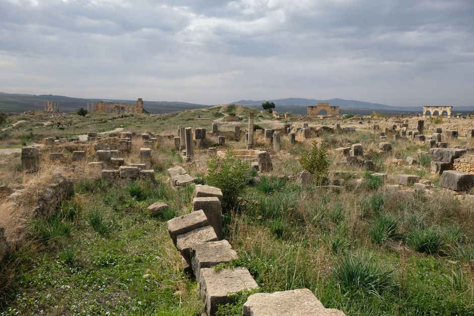 Explore the ancient ruins set against a cloudy Moroccan landscape, perfect for history and travel enthusiasts.