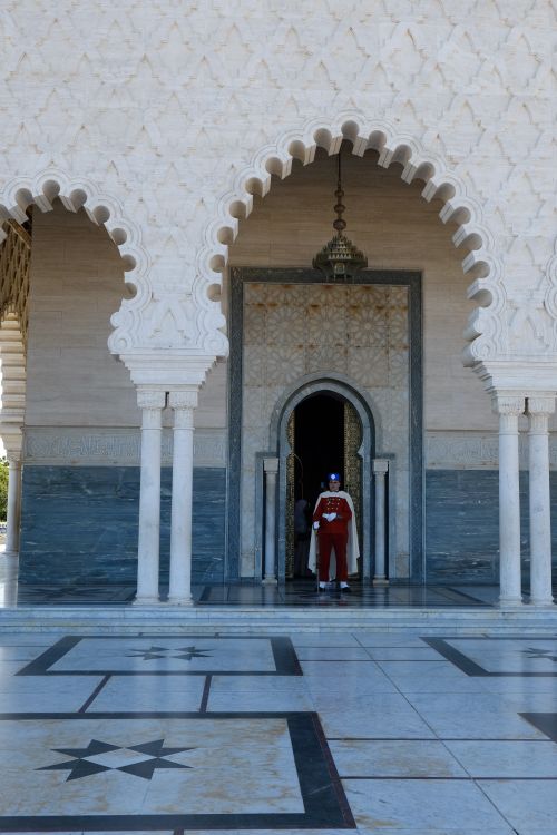 Free Two people enter a mosque with ornate arches in Morocco. Stock Photo