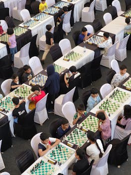 Aerial view of children participating in a chess tournament, focused on strategic play.