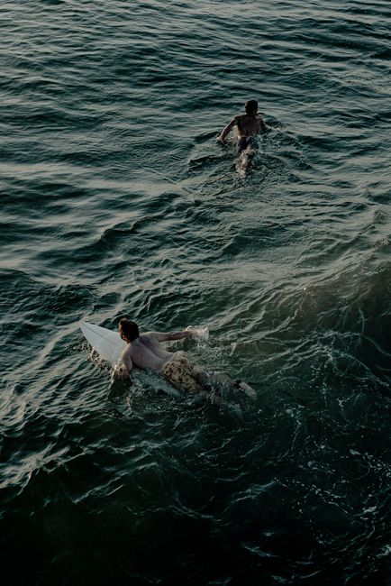 Two surfers paddle out in the ocean waves, enjoying a day of adventure and water sports.