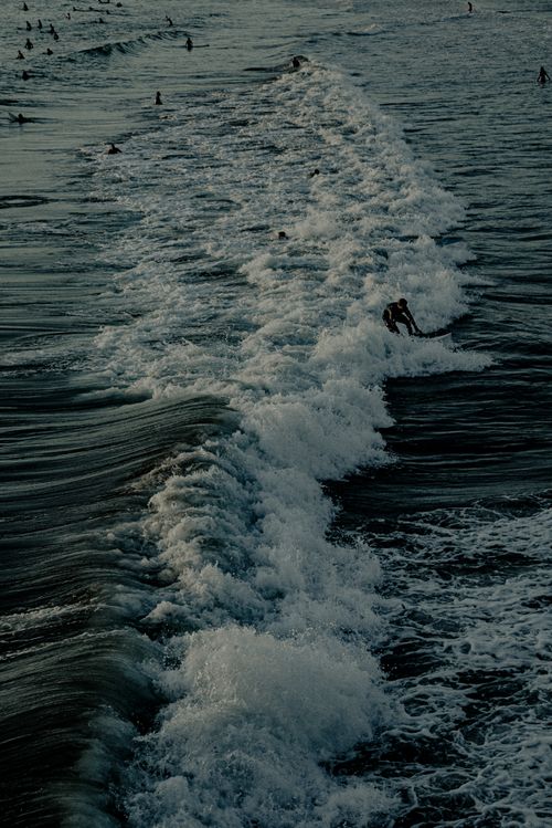 Free Aerial view of surfers enjoying the ocean waves at summer beach. Stock Photo