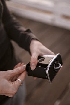 一个人将一卷胶卷放入室内的现代相机，凸显了复古摄影的韵味