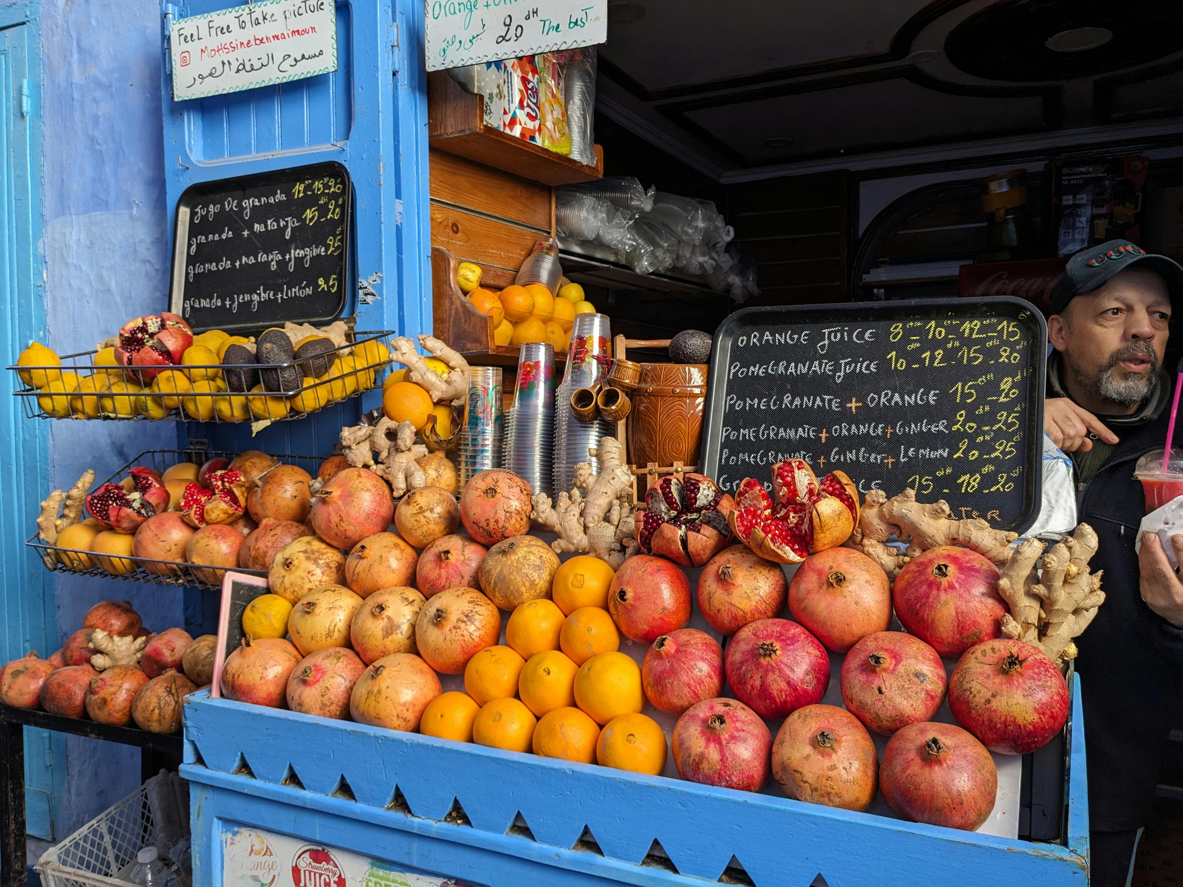 Is Marrakech Safe for Tourists? (Honest Guide) - Colorful fruit stand selling fresh produce and juices in Chefchaouen, Morocco. - Marrakech