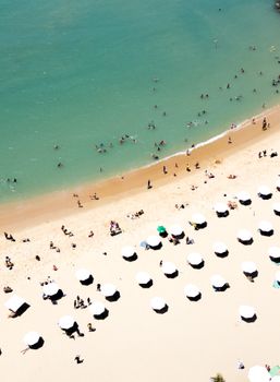 Aerial shot of a lively beach in Fortaleza, Brazil with people enjoying sun and sea.