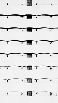 Abstract view of a modern building facade with repetitive arch patterns in black and white.
