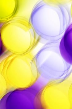 Colorful abstract art featuring blurred yellow and purple circles.