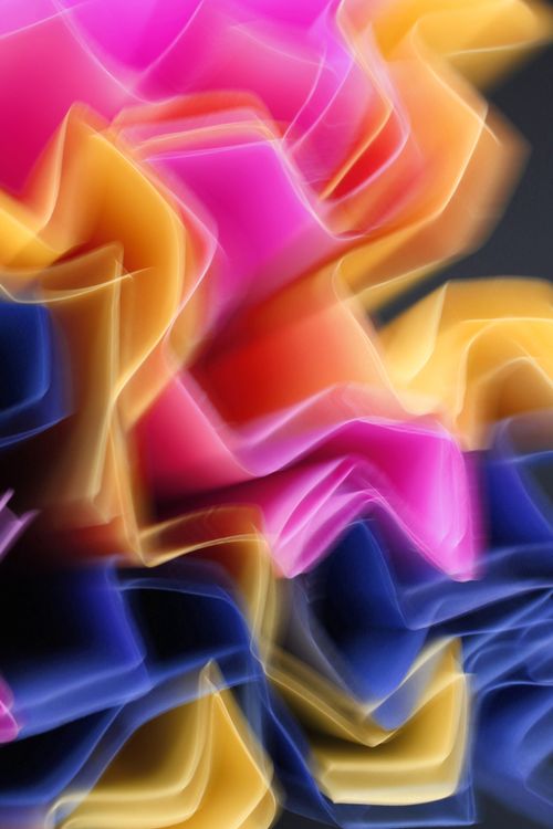 Free Vibrant abstract light trails in pink, yellow, and blue creating a dynamic motion effect. Stock Photo