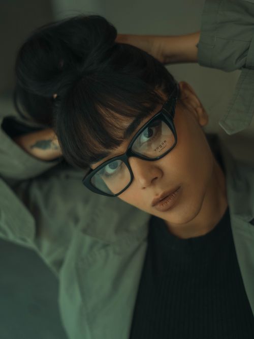 Free Close-up portrait of a fashionable woman wearing glasses with an updo hairstyle. Stock Photo