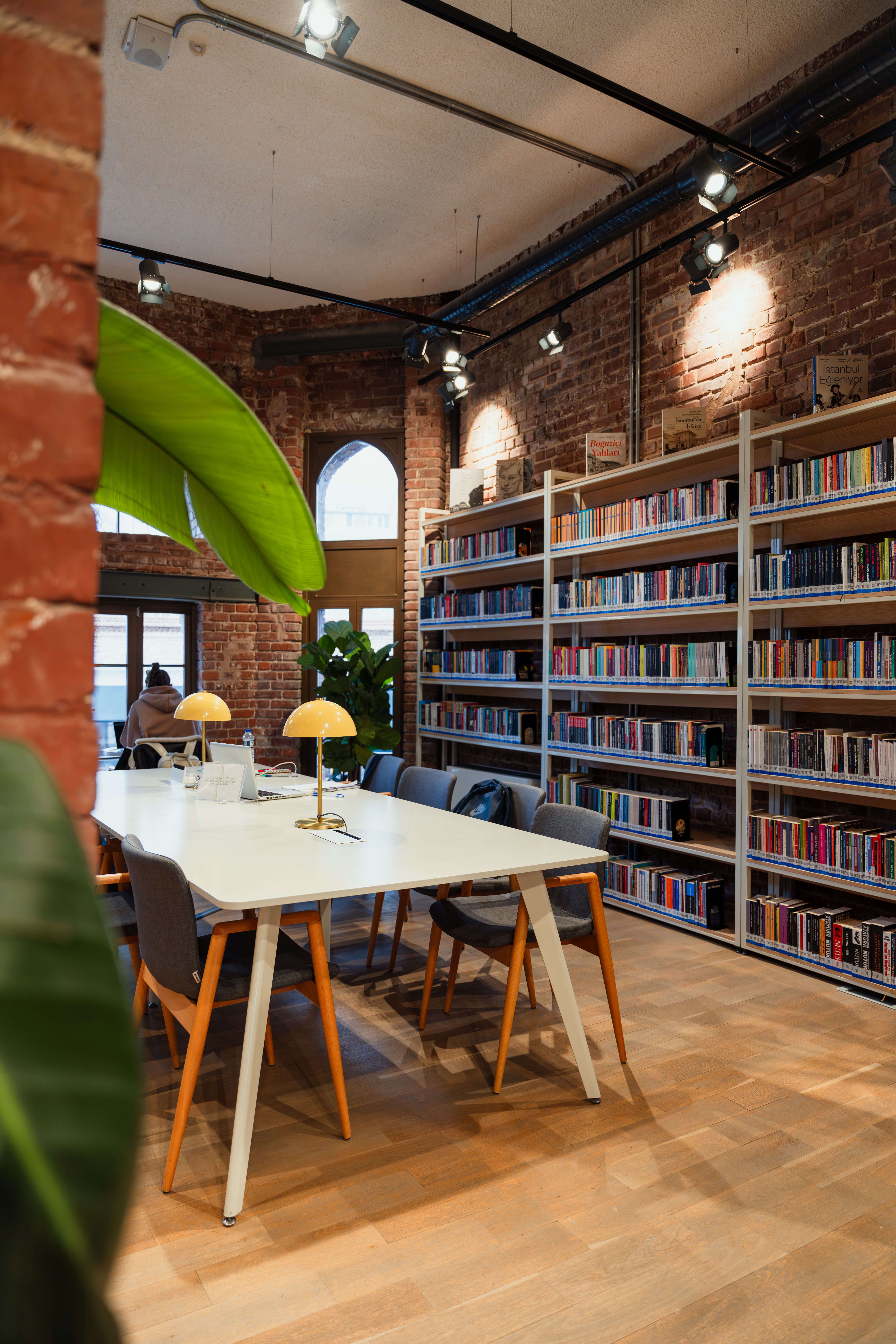 Cozy Brick Library with Reading Tables and Bookshelves · Free Stock Photo