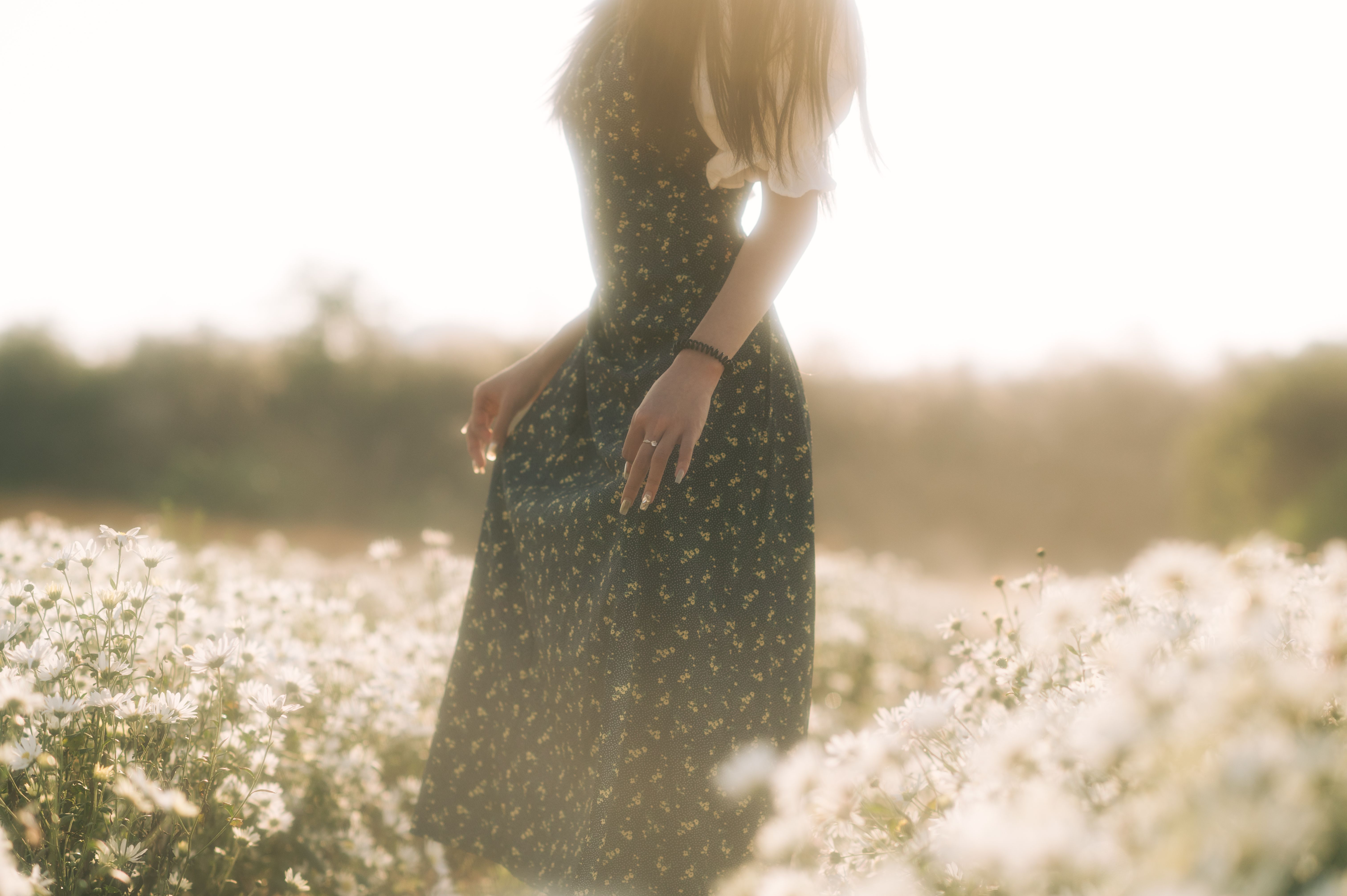 Woman in Floral Dress Strolls Through Daisy Field · Free Stock Photo