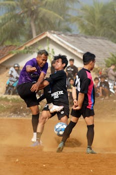Competitive soccer game on a dusty field, capturing intense action and athleticism.