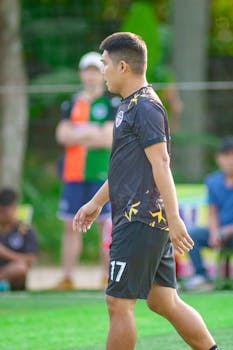 A young soccer player in a jersey, focused on the game, outdoors in Hà Nội.