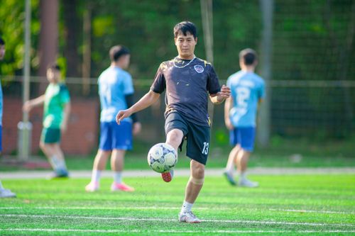Free Teenagers engaging in a lively soccer game on an outdoor field in Hà Nội. Stock Photo