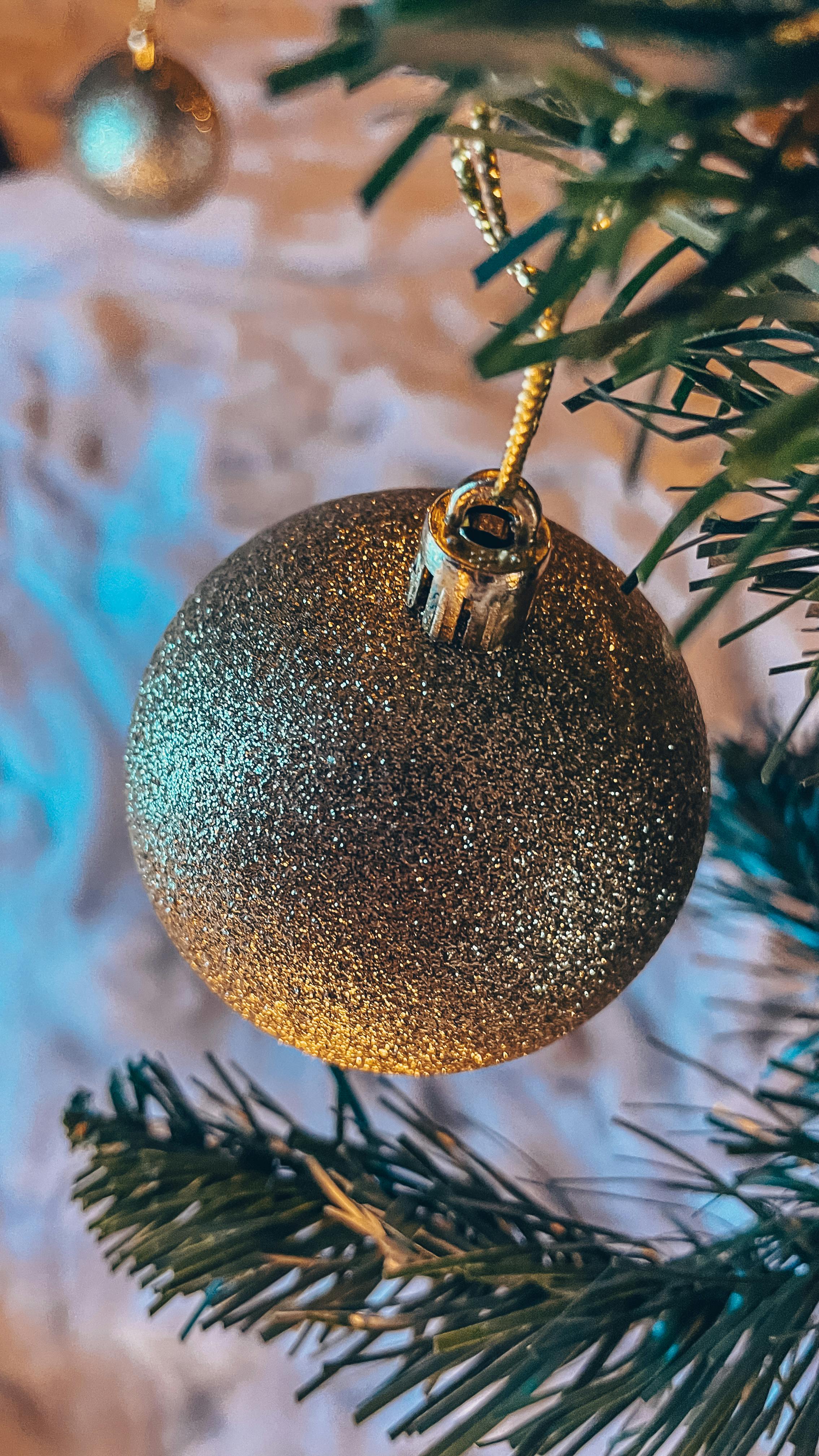 close up of gold christmas ornament on tree