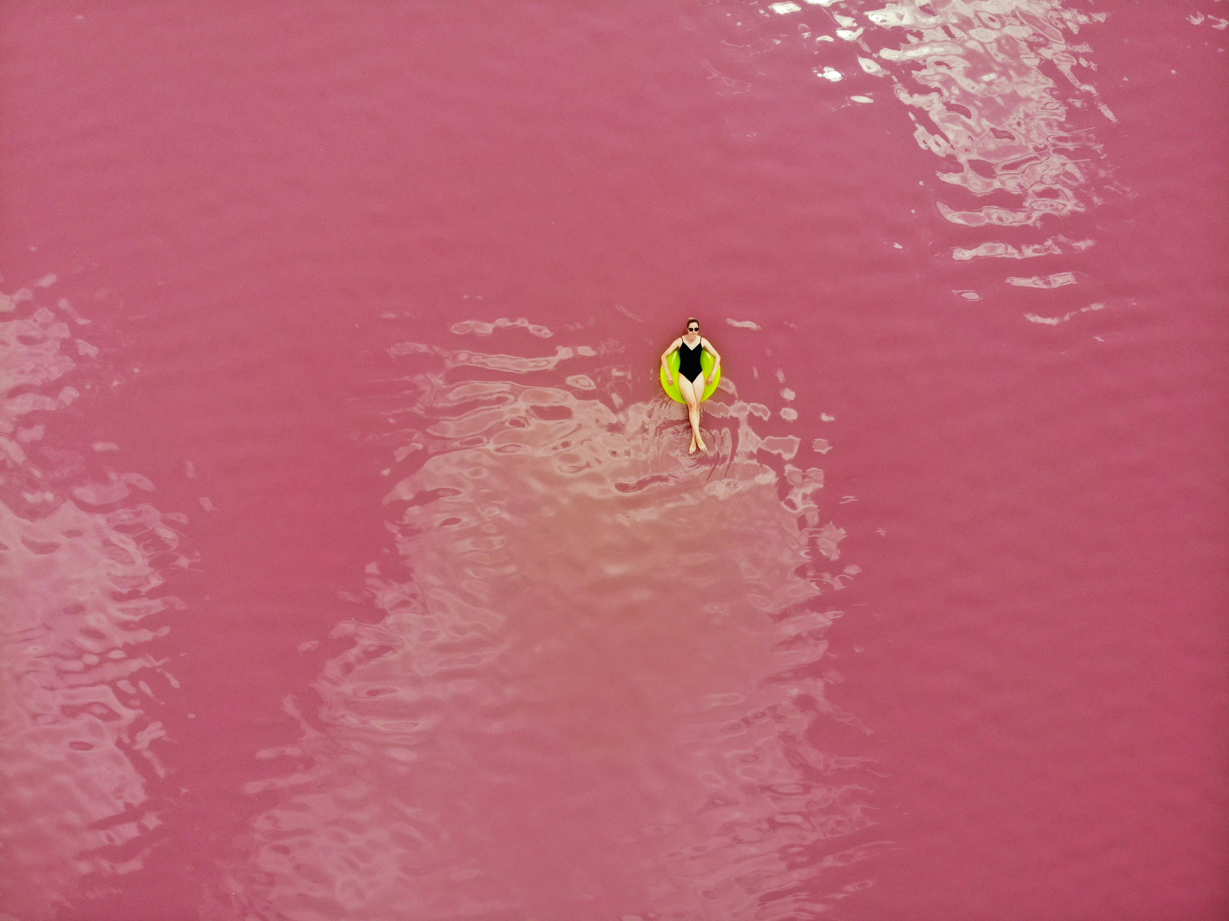 De franc Una vista aèria fascinant d'una dona flotant en un llac rosa a Ucraïna. Moment únic i tranquil capturat. Foto d'estoc