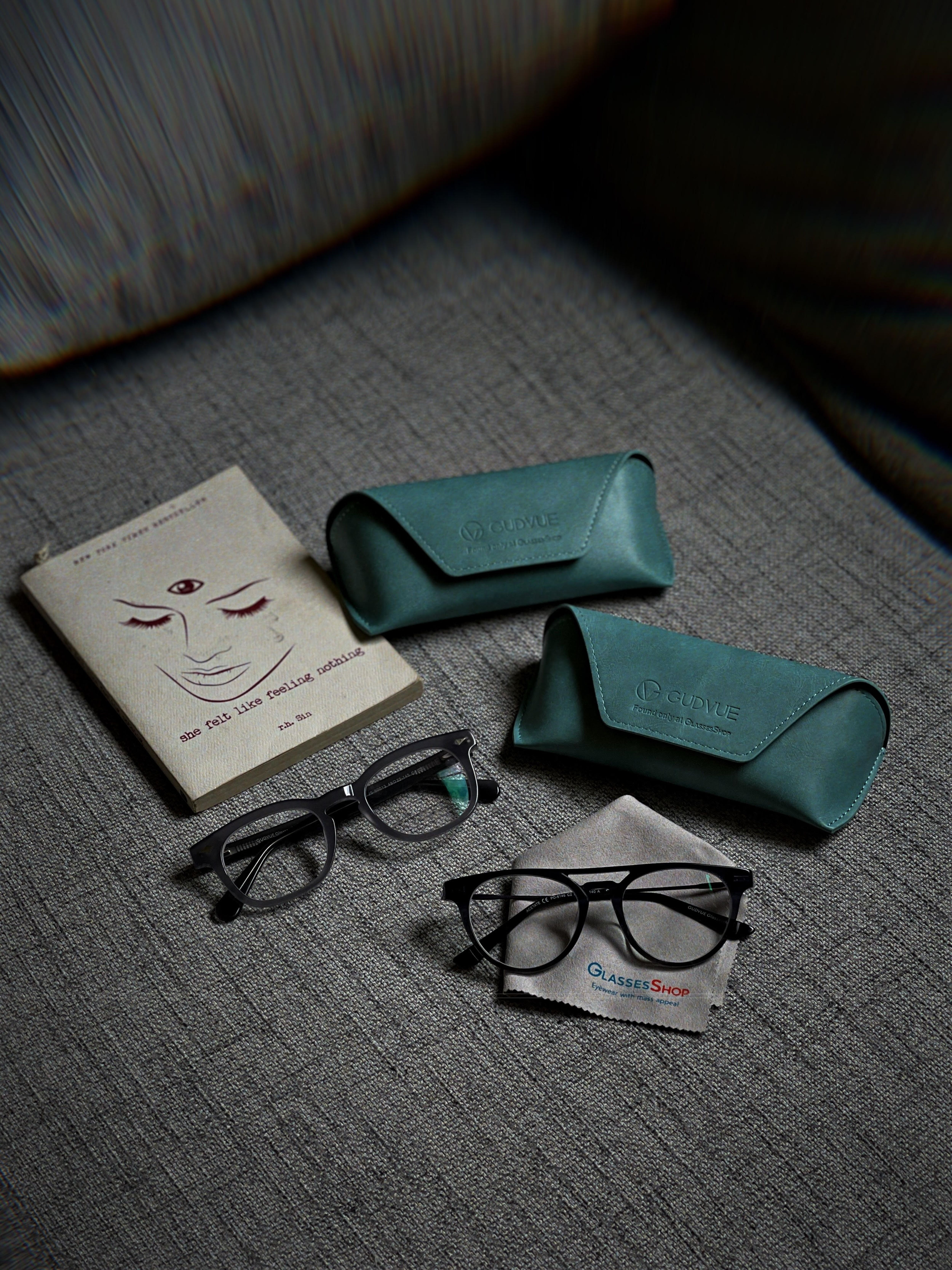 Stylish eyeglasses with cases and a book, perfect for a minimalistic lifestyle setting.