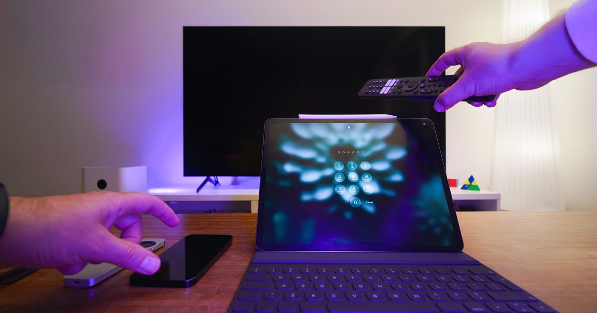 A living room with a tablet, smartphone and television.