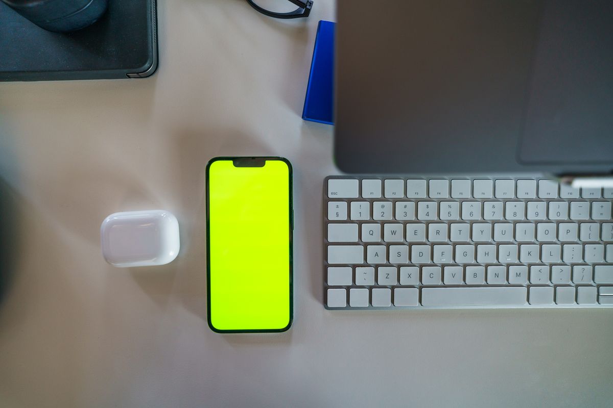 Top view of smartphone, laptop, keyboard, and wireless technology accessories