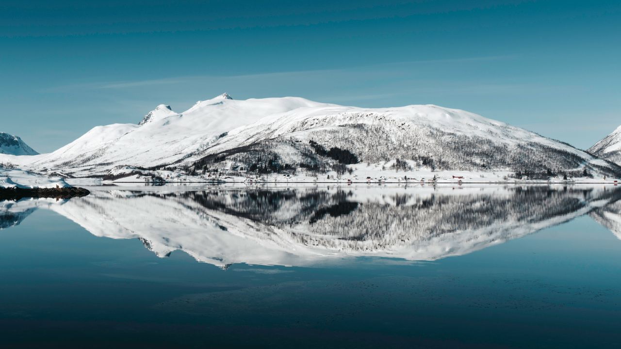 captivating arctic landscape with snow covered mountains mirrored in a