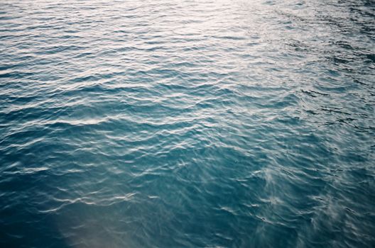 Serene image of blue ocean waves reflecting sunlight, creating a soothing texture.