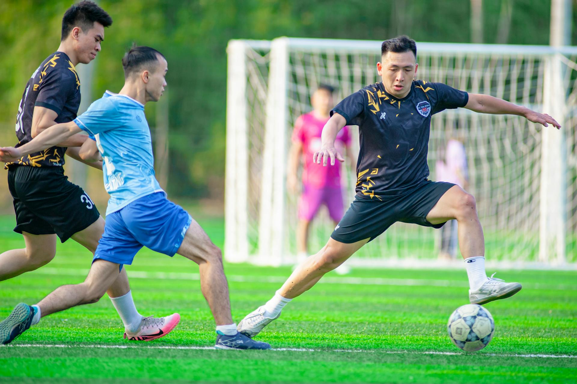 Dynamic soccer match in Hanoi, capturing vivid athletic competition on a bright day.