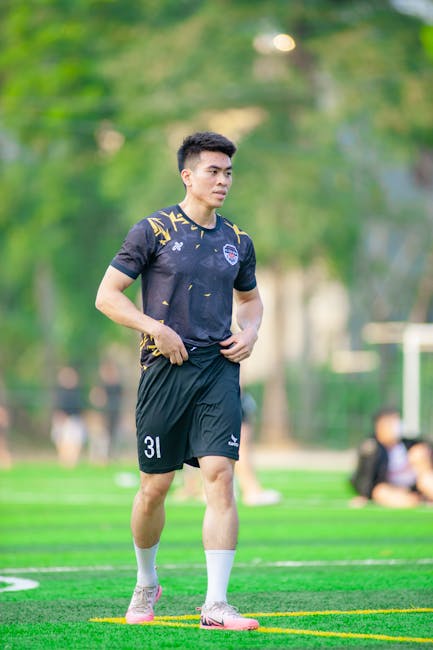 A young man in sportswear playing football in a park in Hanoi, Vietnam.