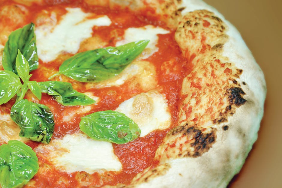 Close-up of a freshly baked Neapolitan pizza with mozzarella and basil leaves.
