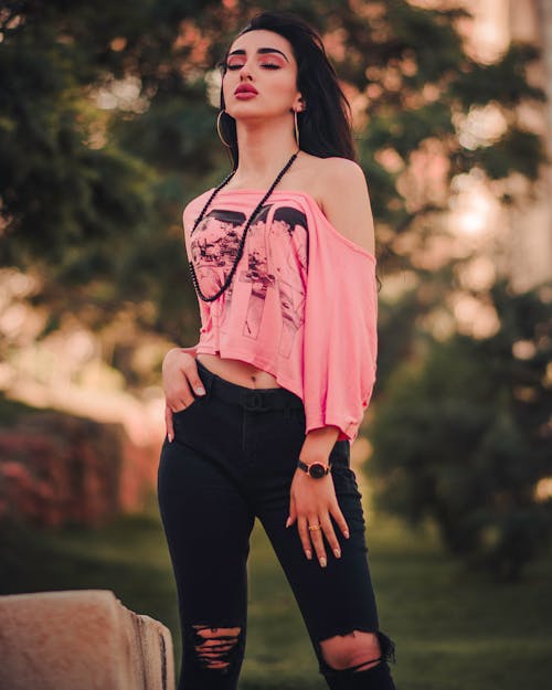 Fotografia Com Foco Diferencial De Mulher Em Pé, Vestindo Camisa Rosa Com Ombro E Calça Jeans Preta