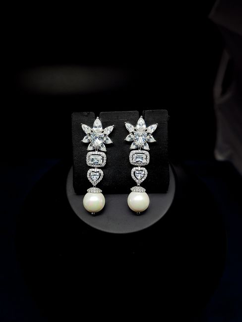 Elegant drop earrings featuring diamonds and pearls, perfect for luxury fashion.
