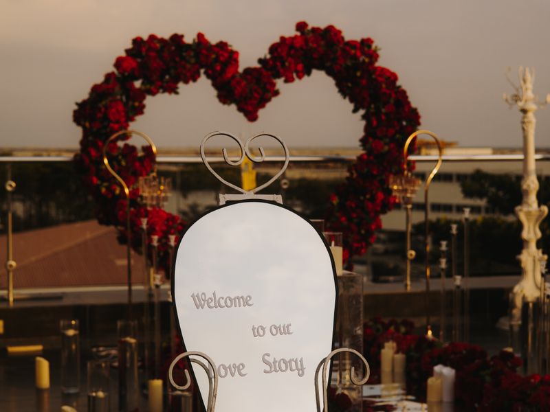 Heart-shaped floral arch with candles outdoors